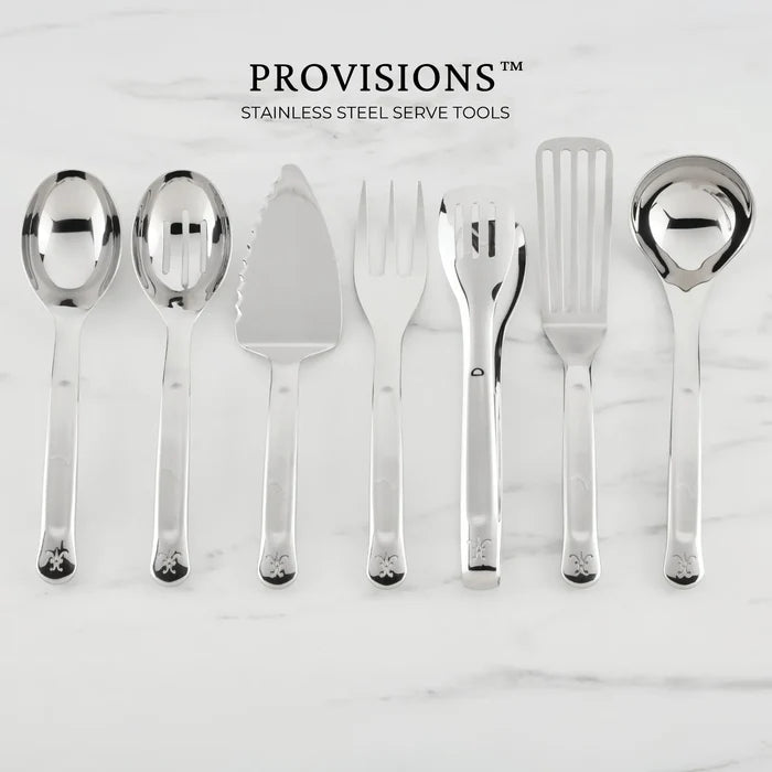 A gleaming Hestan Provisions® 10.5-inch Stainless Steel Slotted Serving Spoon is arranged on a white marble surface—the perfect essential chef’s tool for any kitchen. “PROVISIONS” is written above.