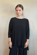 Model wearing the black Kozan Dima tunic with a boat neckline, three-quarter sleeves, and an asymmetrical draped hem, shown from front and back.