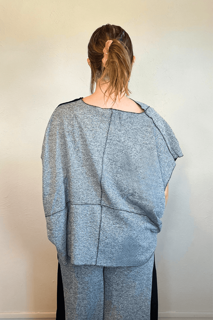 Model wearing the Kozan Fari draped top in heathered gray with black contrast edging, shown from front and back, including a full outfit view with coordinating pants.