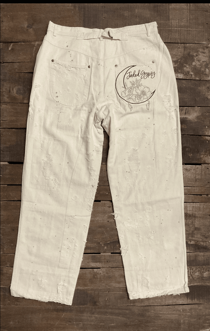 Jaded Gypsy Parchment Peace And Love Jeans with distressed details, PEACE leg graphic, floral artwork, and embroidered back design