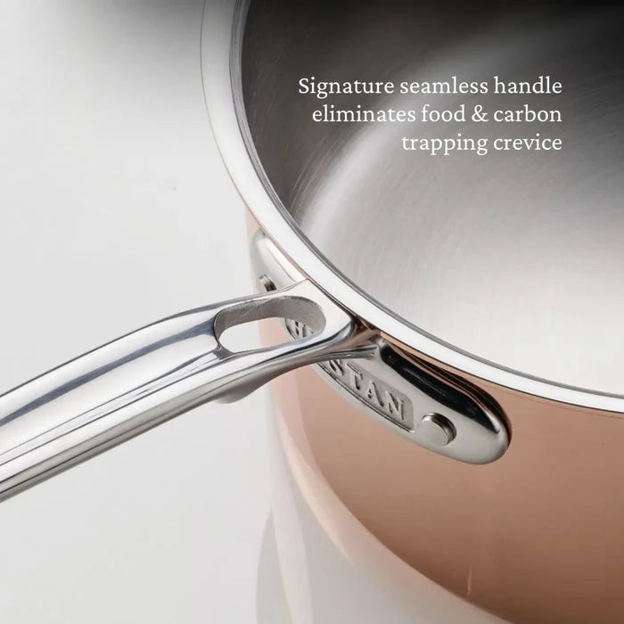 Close-up of the CopperBond Aura™ Polished Copper 0.75-Quart Butter Warmer featuring a professional-grade copper body and a seamless stainless steel handle. Text on the image reads: Signature seamless handle eliminates food & carbon trapping crevice.