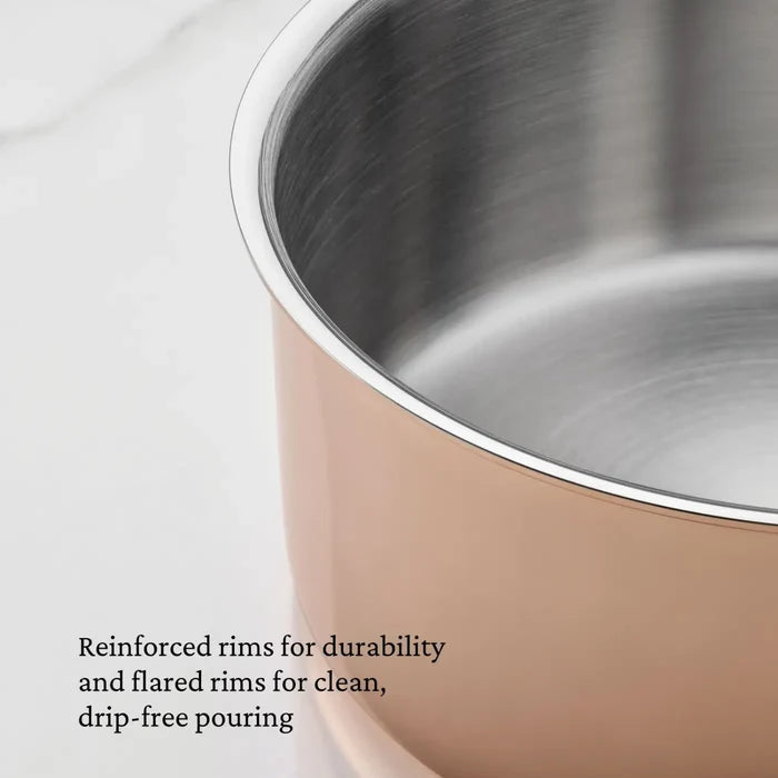 A close-up of the CopperBond Aura™ Polished Copper 0.75-Quart Butter Warmer shows its stainless steel interior and striking copper-colored exterior, styled with reinforced, flared rims for a professional-grade look. A caption in the lower left corner highlights its durability and drip-free pouring.
