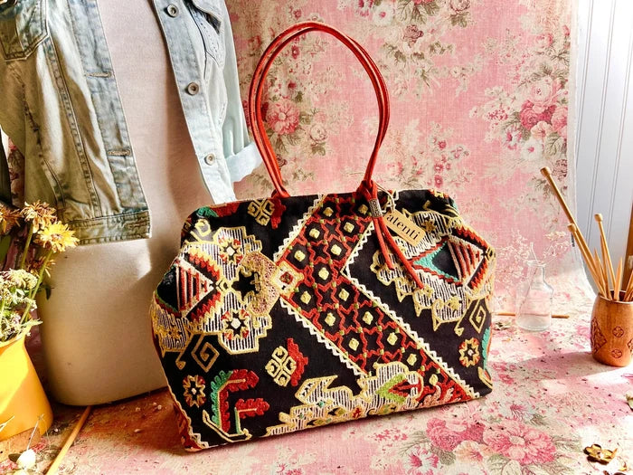 Atenti Sew Crewel Pioneer handbag with multicolor crewel-style embroidery, bright red double handles, and structured snap-frame silhouette
