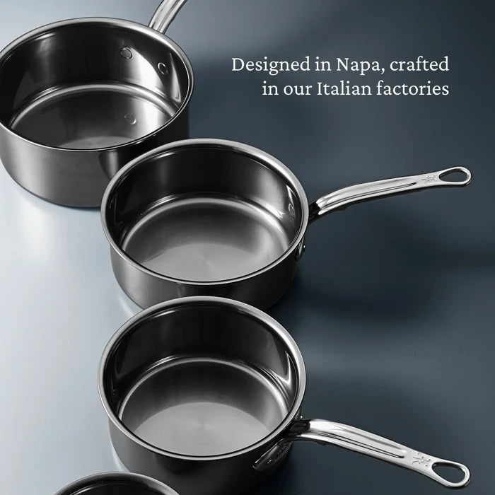 Three Titanium Saucepans with handles from NanoBond® are arranged diagonally on a blue-gray surface. White text reads, Designed in Napa and crafted in our Italian factories, these NanoBond® Titanium Saucepans showcase the innovation of Molecular Titanium Cookware.